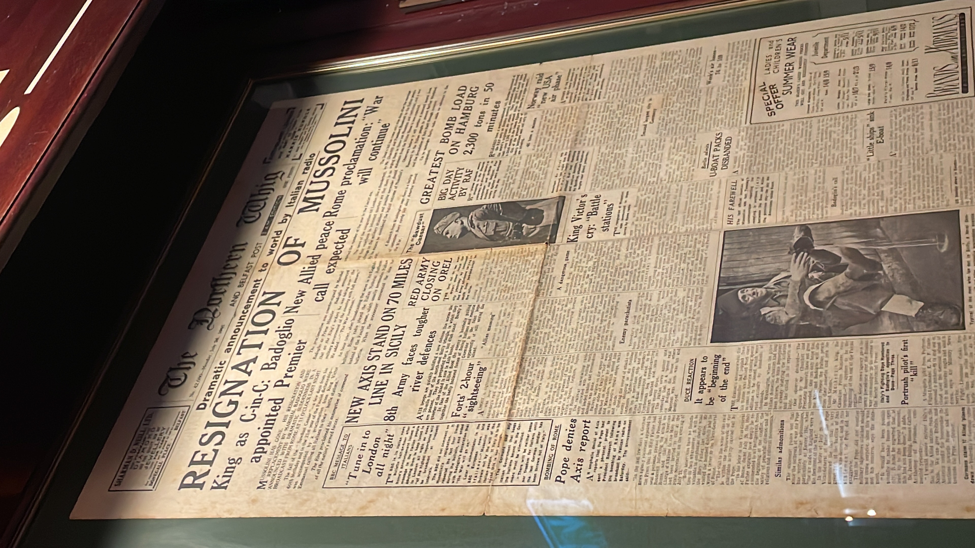 A newspaper front page in a frame reporting Mussolini’s resignation